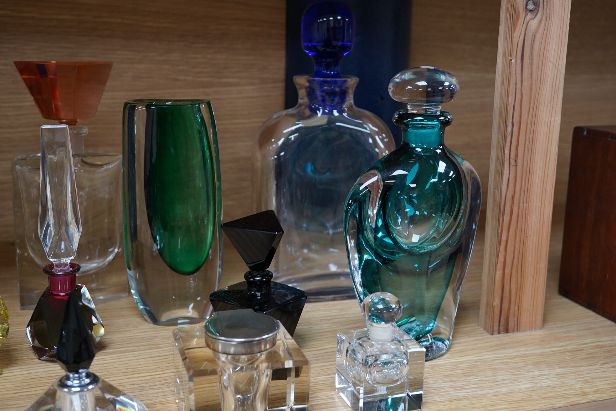 Eighteen glass scent bottles, two silver mounted, tallest 24.5cm, and a glass vase. Condition - good